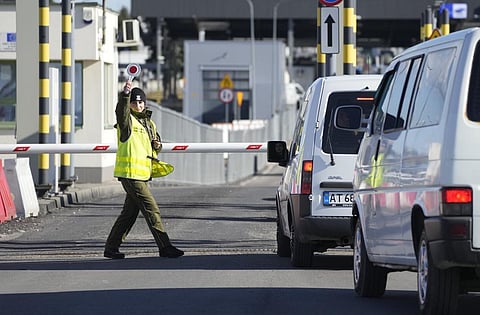 A Polish border guard gives instructions as drivers wait to cross the border from Poland into Ukraine in Medyka, Poland, on Saturday, Feb. 19, 2022. (Photo | AP)