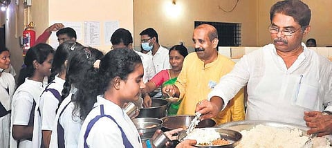 Revenue Minister R Ashoka serves breakfast to students of Morarji Desai Residential School in Alooru in Udupi district on Sunday (Photo | EPS)