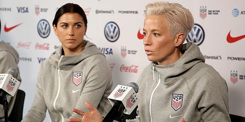 United States women's national soccer team member Alex Morgan (L) listens as teammate Megan Rapinoe speak to reporters during a news conference in New York, May 24, 2019. (File Photo | AP)