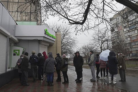 People line up to withdraw their money from an ATM in Mariupol, Ukraine, Thursday, Feb. 24, 2022. (Photo | AP)