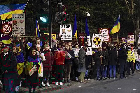 Demonstrators hold placards and Ukraine's flags as they attend a protest outside the Russian Embassy, in London, Wednesday, Feb. 23, 2022. (Photo | AP)