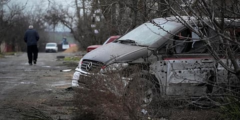 A man walks past a damaged vehicle and debris following Russian shelling in Mariupol, Ukraine, Thursday, Feb. 24, 2022. (Photo | AP)
