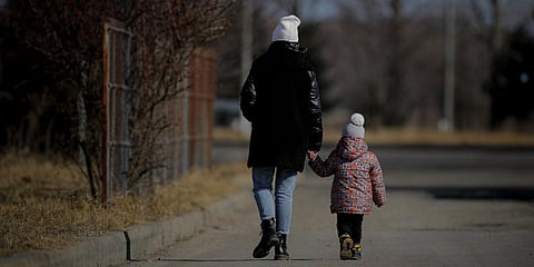 A woman holds a child's hand after crossing the border from Ukraine at the Romanian-Ukrainian border, in Siret, Romania. (Photo | AP)