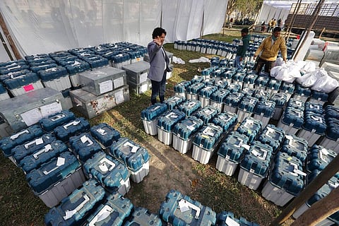 Election officials gather at a distribution center to receive electronic voting machines and other polling material.