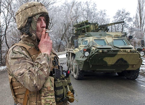 A Ukrainian soldier smokes a cigarette on his position at an armored vehicle outside Kharkiv, Ukraine, Saturday, Feb. 26, 2022. (Photo | AP)