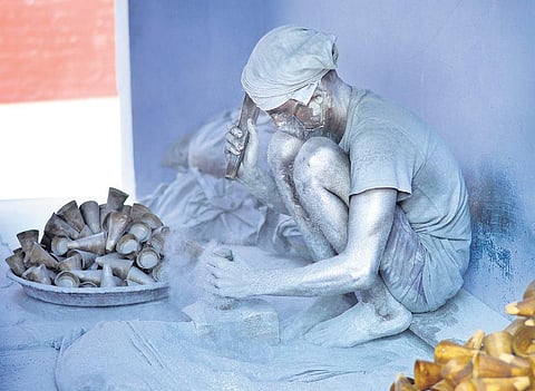 File picture of a worker filling fire cracker moulds with chemicals at unit in Sivakasi