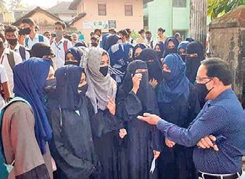 The principal of the Government PU College in Kundapur talks to the students who came wearing the hijab on Thursday | Express