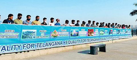 A group of TRS supporters stand with a banner which demands Equality for Telangana, at Tank Bund, on Saturday