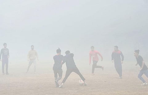 Youngsters play ball amid dense fog in New Delhi on Saturday. (Photo | Shekhar Yadav)