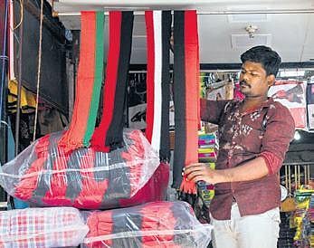 A shopkeeper at Periyakadai Veethi displays towels & scarves | MK Ashok Kumar