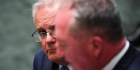 Australian Prime Minister Scott Morrison, rear, listens to Australian Deputy Prime Minister Barnaby Joyce in the Parliament House in Canberra Feb 8, 2022. (Photo | AP)
