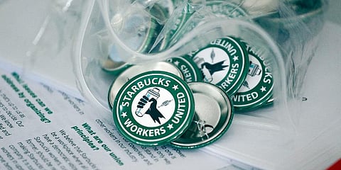 FILE — Pro-union pins sit on a table during a watch party for Starbucks' employees union election, Dec. 9, 2021, in Buffalo, N.Y. (Photo | AP)