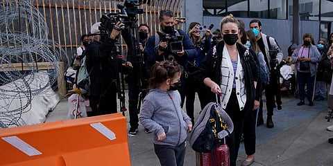A woman from Ukraine walks with her children as they cross into the United States, Thursday, March 10, 2022, from Tijuana, Mexico. (Photo | AP)