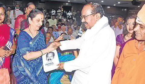 Former CM M Veerappa Moily hands a copy of his autobiography to his wife Malati, at Ravindra Kalakshetra in Bengaluru on Saturday | Vinod Kumar T