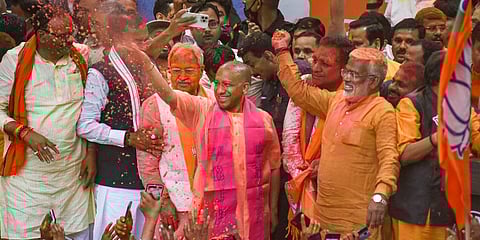 Uttar Pradesh CM Yogi Aditiyanath greets party workers during celebrations following their win in the Assembly polls, at the BJP office in Lucknow. (Photo | PTI)