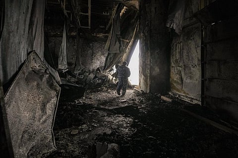 A staff member exits a large food products storage facility which was destroyed by an airstrike north of Kyiv, Ukraine on March 13,2022(Photo | AP)
