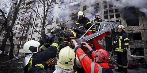In this photo released by Ukrainian State Emergency Service press service, firefighters evacuate a man from an apartment building hit by shelling in Kyiv, Ukraine, Monday, March 14, 2022. (Photo | AP)