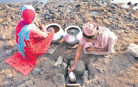 Women fill their vessels with water from the pit in Jhupuripara | Express