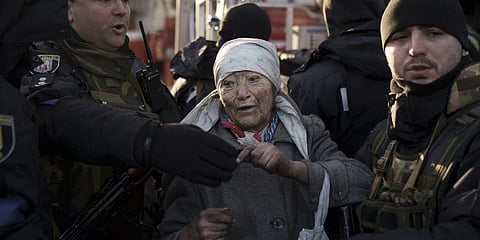An elderly woman is helped by policemen after she was rescued by firefighters from inside her apartment after bombing in Kyiv, Ukraine, Tuesday, March 15, 2022. (Photo | AP)