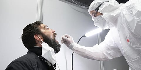 Danilo Schulz sits during a Corona quick test at the Johanniter Corona Test Center in the Palace of Culture in Dresden, Germany, Wednesday, March 16, 2022. (Photo | AP)