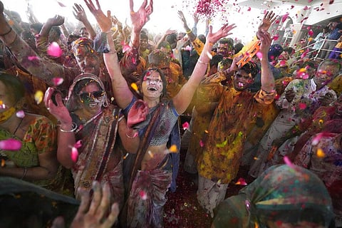 Devotees cheer as colored powder and flower petals are thrown on them during celebrations marking Holi at the Swaminarayan temple and Lord Jagannath temple in Ahmedabad. (Photo | AP)