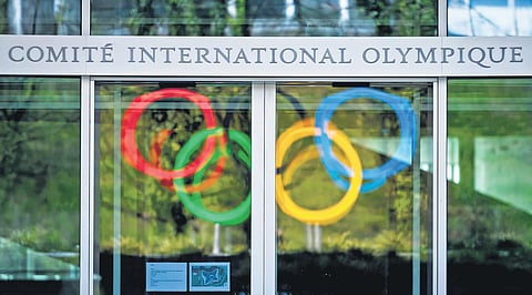 The Olympic rings are reflected on the windows at the headquarters of the International Olympic Committee. (File photo | AFP)