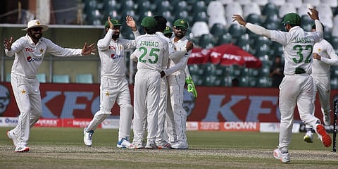 Pakistan's Babar Azam, center, and teammates celebrate after the dismissal of Australia's Steve Smith on the first day of the third test match on March 21, 2022.(Photo | AP)