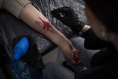 Ukrainian Natalia Tanchynets works on a patriotic-themed tattoo at her workshop in Lviv, Western Ukraine, Saturday, March 19, 2022. (Photo | AP)