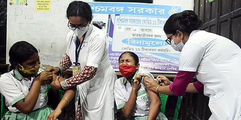 Students react while receiving a dose of COVID-19 vaccine during a vaccination drive for 12-14 years of age group, in Kolkata. (Photo| ANI)