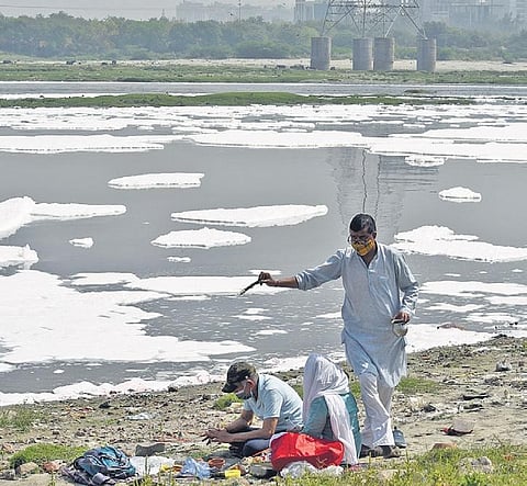 People perform rituals on the banks of a polluted Yamuna . ( Photo | EPS)