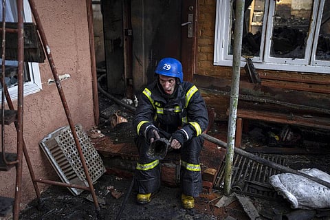 A Ukrainian firefighter takes a break from extinguishing a fire inside a house destroyed by shelling in Kyiv, Ukraine. (Photo | AP)