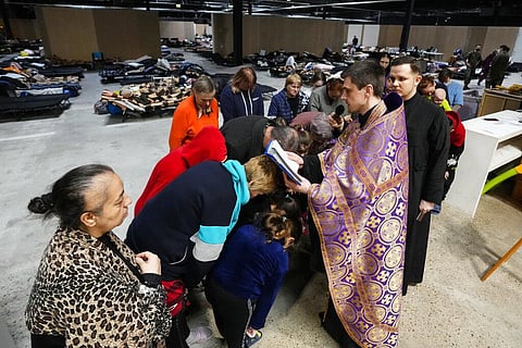 Orthodox priest Tomasz Paszko leads a service in a refugee center in Nadarzyn, near Warsaw, Poland, on Friday, March 25, 2022. (Photo | AP)
