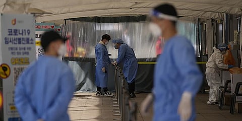 Health workers in protective gear prepare for visitors at a temporary screening clinic for the coronavirus in Seoul, South Korea, Monday, March 28, 2022. (Photo | AP)
