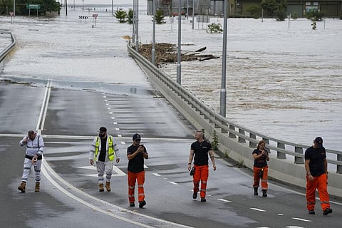 State emergency staff stand near the entrance to the flooded Windsor bridge on the outskirts of Sydney, Australia, Thursday, March 3, 2022(Photo | AP)