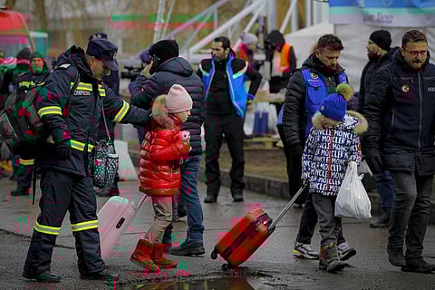 A firefighter helps refugees fleeing the conflict from neighbouring Ukraine at the Romanian-Ukrainian border, in Siret, Romania. (Photo | AP)