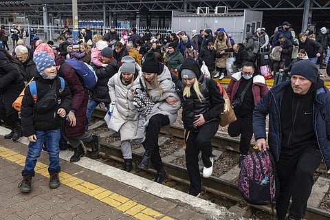 People, mostly women and children, try to get onto a train bound for Lviv, at the Kyiv railway station, Ukraine. (Photo | AP)