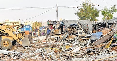 An earthmover pulls down huts in one of the two slum clusters near Moosarambagh bridge in Hyderabad on Friday, March 4, 2022. (Photo | EPS, Vinay Madapu)
