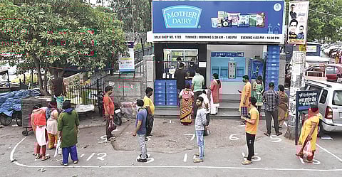 People stand in a queue outside a Mother dairy booth. (Photo | Parveen Negi, EPS)
