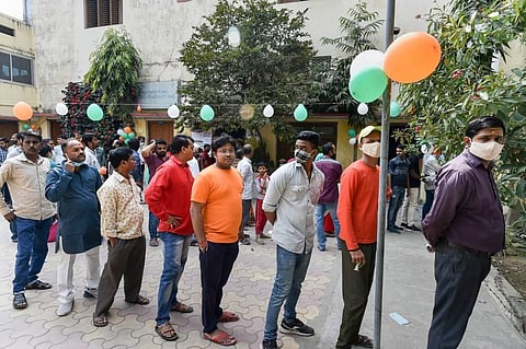 Citizens wait to cast their vote, during the seventh and last phase of Uttar Pradesh Assembly elections, outside a polling booth in Varanasi. (Photo | PTI)