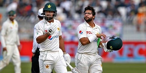 Pakistan's Abdullah Shafique (L) and Imam-ul-Haq walks back to pavilion on the tea break during Day 5 of 1st Test match against Australia in Rawalpindi. (Photo| AP)