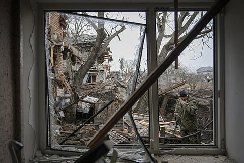 A member of territorial defense wipes his face in the backyard of a house that was damaged by a Russian airstrike. (Photo | AP)