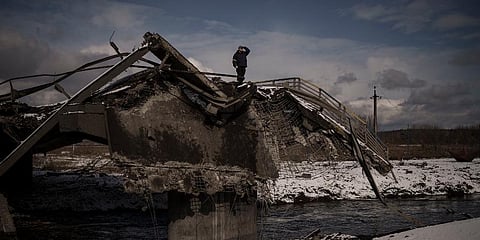 A man stands atop a destroyed bridge in Irpin, on the outskirts of Kyiv, Ukraine, Tuesday, March 8, 2022. (Photo | AP)