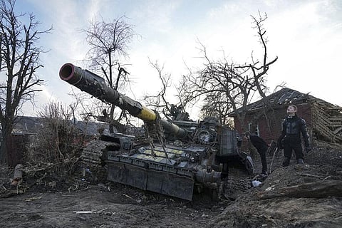 Men stand next to a destroyed tank. Image used for representational purpose. (Photo | AP)