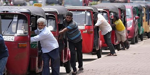 Sri Lankan auto rickshaw drivers queue up to buy petrol near a fuel station in Colombo. (Photo | AP)