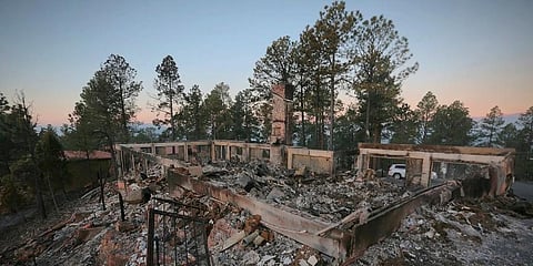 A two-story house continues to smolder following the McBride Fire in Ruidoso. (Photo | AP)