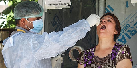 A healthworker collects swab samples of residents for COVID-19 testing, in Gurugram. (Photo| PTI)
