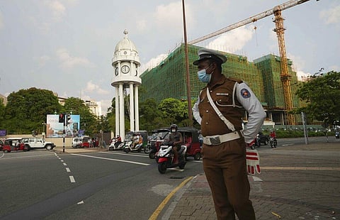 A Sri Lankan police officer stands in a street as curfew begins in Colombo, Sri Lanka, Saturday, April 2, 2022. (Photo | AP)