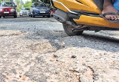 A two-wheeler rider navigating the potholes on the dilapidated Vazhuthacaud-Thycaud stretch in front of the Women’s College | B P Deepu