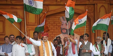Union Home Minister Amit Shah with others waves the national flag during Veer Kunwar Singh Vijayotsav at Jagdishpur, in Bhojpur. (Photo | PTI)