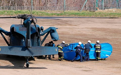 Firefighters transfer a rescued person from a helicopter in Shari, in the northern island of Hokkaido . ( Photo | AP)